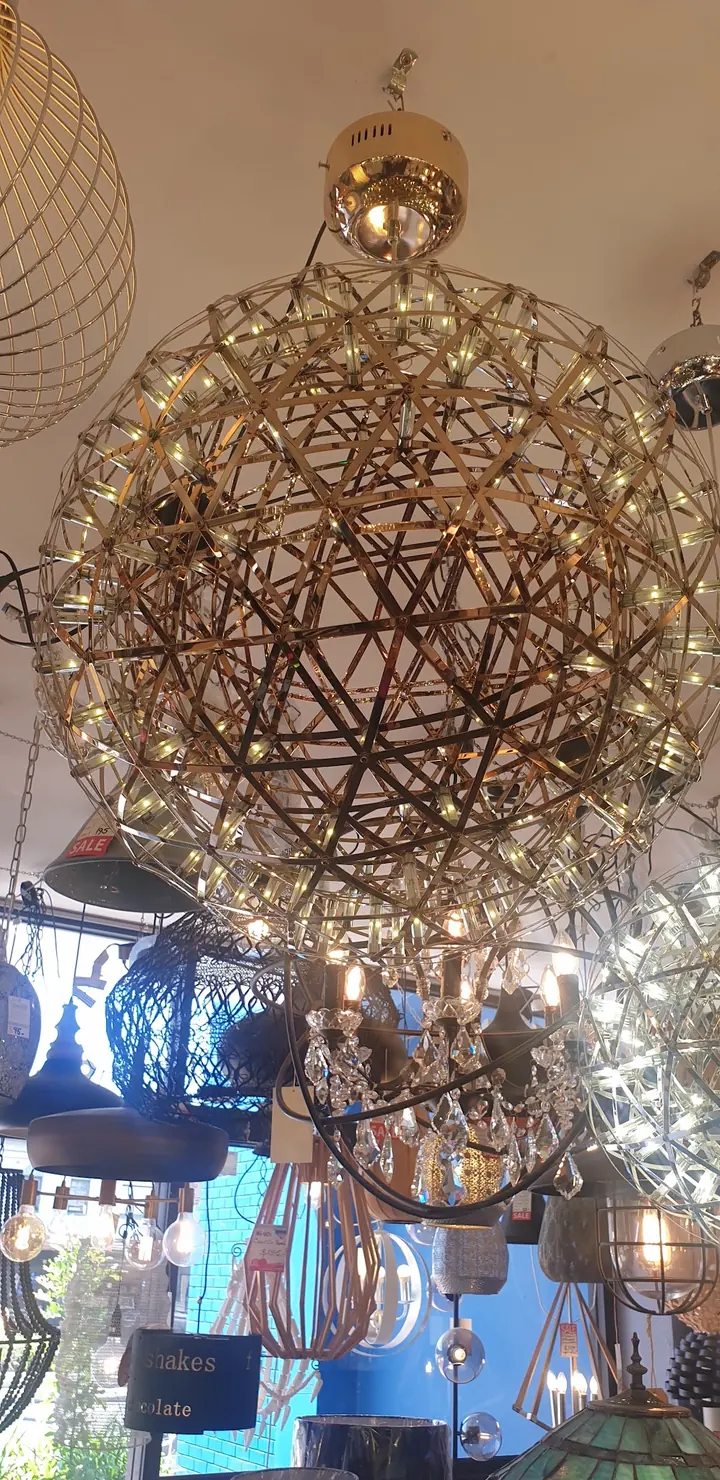 A sphere chandelier of glass rods lit in the Cosmo Lighting showroom