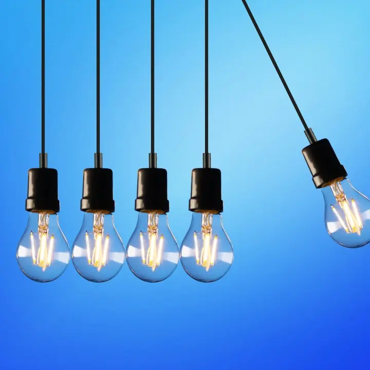 Five filament LED globes hanging on bare black pendant cords