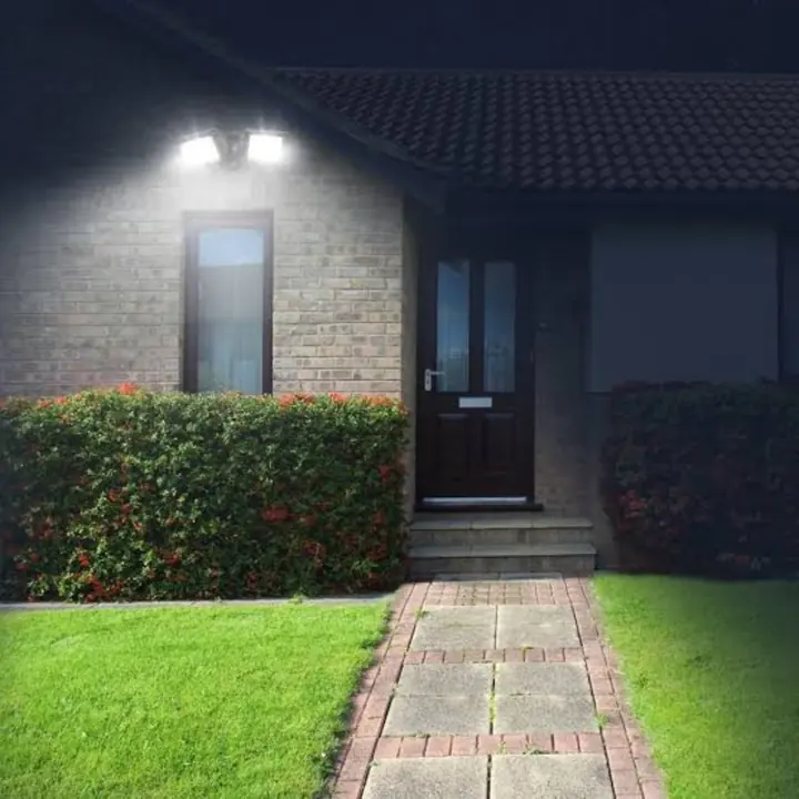 A security flood light lighting a front path at night