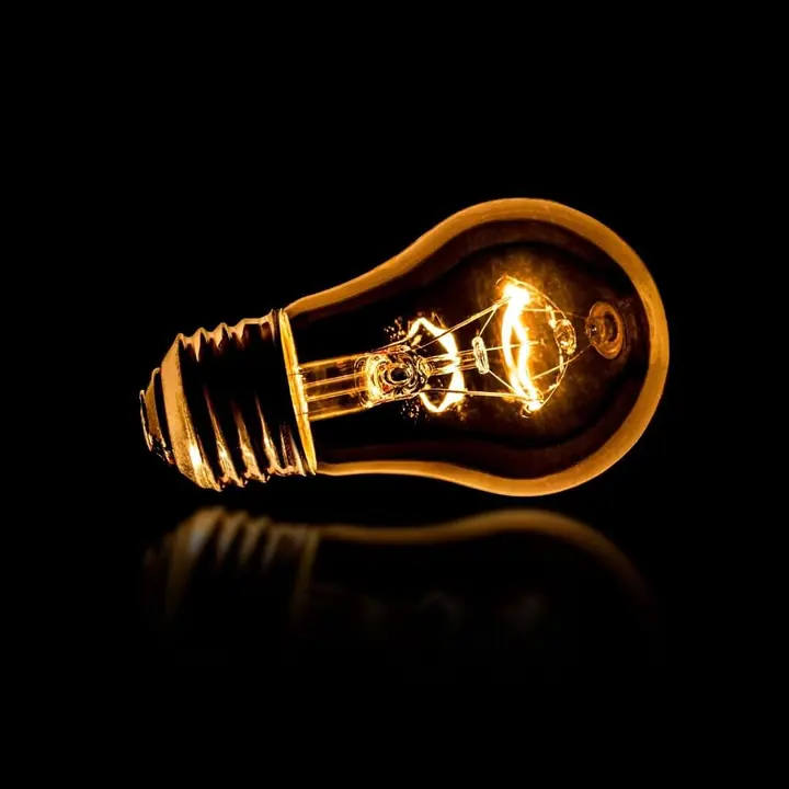 A single lit filament globe against black
