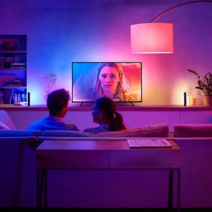 A lounge room lit in blue and pink by smart lighting